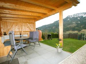 a patio with a table and chairs and a mountain at Apartment Venet by Interhome in Fliess