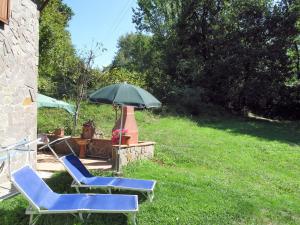 2 chaises et un parasol dans la cour dans l'établissement Holiday Home Grande Quercia by Interhome, à Pallerone