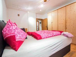 - une chambre dotée d'un lit avec des oreillers roses dans l'établissement Apartment Höpperger by Interhome, à Flaurling