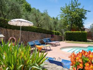 a patio with chairs and an umbrella next to a pool at Holiday Home Il Sorbino by Interhome in Fondaccio