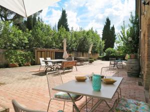 a patio with a table and chairs and an umbrella at Apartment Violapo al Castello by Interhome in Monte Antico