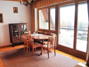 a dining room with a table and chairs and windows at Chalet Partecznik by Interhome in Wisła