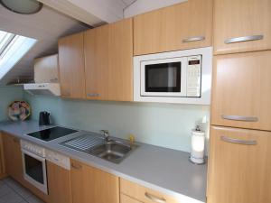 a small kitchen with a sink and a microwave at Apartment Schallhart by Interhome in Terfens