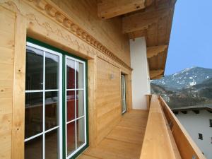a balcony of a wooden house with a large window at Apartment Pfeifer-2 by Interhome in Pians