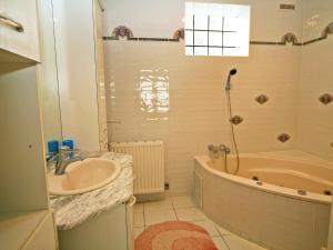 ein Badezimmer mit einem Waschbecken, einer Badewanne und einer Dusche in der Unterkunft Holiday Home Friedl by Interhome in Ritzing