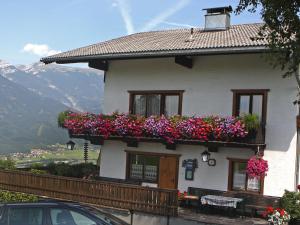 a house with flowers on the side of it at Apartment Jägerhof-2 by Interhome in Hochpillberg