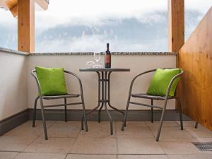 ペットイ・アム・アールベルクにあるApartment Bella Monte-2 by Interhomeのテーブル(椅子2脚付)とワイン1本