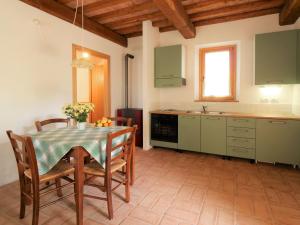 BoccheggianoにあるHoliday Home La Valle by Interhomeのキッチン(テーブル、椅子付)、キッチン(緑のキャビネット付)