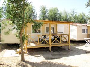 a tiny house with a porch in a yard at Holiday Home 4 Mori- Deluxe - MUV105 by Interhome in Muravera
