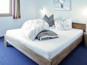 a bed with pillows on it in a room at Apartment Luxner - KAB137 by Interhome in Kaltenbach