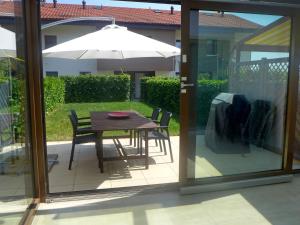 a patio with a table and chairs and an umbrella at Holiday Home Route de Coinsin by Interhome in Saint-Prex