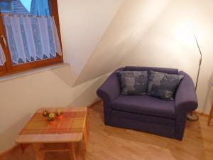NeuriedにあるApartment Dieboldshof by Interhomeのリビングルーム(紫色の椅子、テーブル付)
