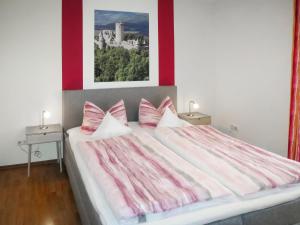 um quarto com uma cama grande com lençóis cor-de-rosa e brancos em Apartment Weinand by Interhome em Kottenborn