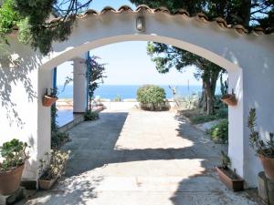 an archway leading to the ocean from a villa at Apartment Sulla Scogliera by Interhome in Santa Domenica