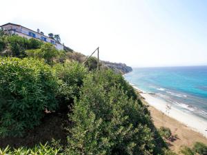 a house on top of a hill next to the ocean at Apartment Sulla Scogliera by Interhome in Santa Domenica