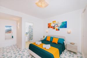 a bedroom with a bed and a painting on the wall at Villa Eris Amalfi Coast in Conca dei Marini