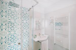 a white bathroom with a sink and a shower at Villa Eris Amalfi Coast in Conca dei Marini