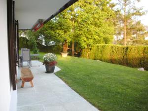 a garden with a lawn and a patio at Apartment Tanno by Interhome in Alvaschein