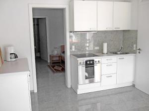 Apartment Willmann by Interhome في إيسينباخ: مطبخ بدولاب بيضاء وموقد