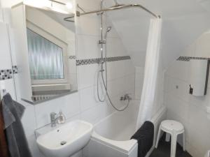 a white bathroom with a sink and a shower at Apartment Weingut Krempel by Interhome in Traben-Trarbach