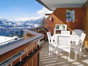 a balcony of a house with a table and chairs at Apartment Mountain Lake Panorama by Interhome in Sundlauenen