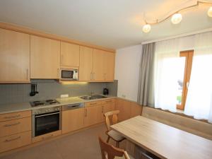 a kitchen with wooden cabinets and a wooden table at Holiday Home Chalet Alpin by Interhome in Kaprun