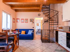 een woonkamer met een blauwe bank en een wenteltrap bij Holiday Home Ribes by Interhome in Consiglio di Rumo