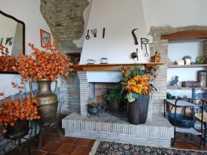 a fireplace with two large vases with flowers in it at Holiday Home Maria Rosaria by Interhome in Ginestreto