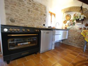a kitchen with an oven and a stone wall at Holiday Home Maria Rosaria by Interhome in Ginestreto +27 photos