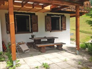 una mesa de picnic y un banco frente a una casa en Apartment Montana by Interhome, en Langwies