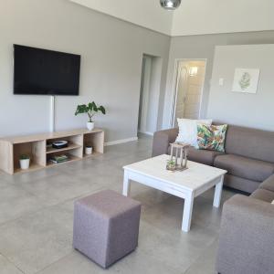 a living room with a couch and a table and a tv at Clarens Escape (Unit 3) in Clarens