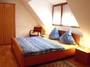 ein Schlafzimmer mit einem Bett mit blauen Kissen und einem Fenster in der Unterkunft Apartment Dieboldshof by Interhome in Neuried