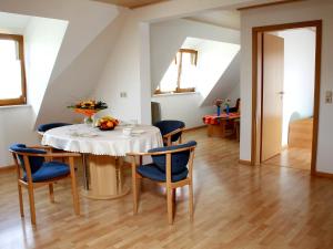 ein Esszimmer mit einem weißen Tisch und blauen Stühlen in der Unterkunft Apartment Dieboldshof by Interhome in Neuried