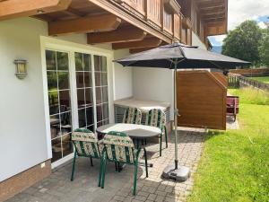 a table and chairs with an umbrella on a patio at Apartment Top 1 by Interhome in Sankt Margarethen im Lungau