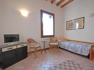 ヴェネツィアにあるApartment Barbaria de le Tole by Interhomeのベッド、テレビ、椅子が備わる客室です。