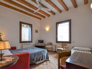 ヴェネツィアにあるApartment Barbaria de le Tole by Interhomeのベッドルーム1室(ベッド1台、テーブル、椅子付)