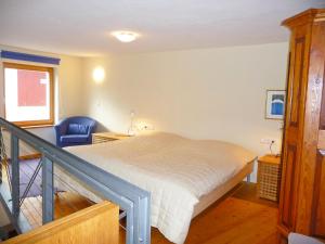 - une chambre avec un lit et une chaise bleue dans l'établissement Apartment Haus Schanbacher by Interhome, à Sterneck