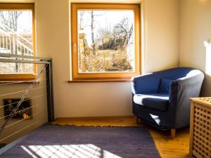 a living room with a blue chair and a window at Apartment Rosengarten by Interhome in Sterneck