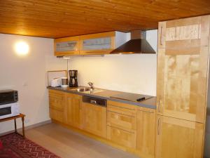 a kitchen with wooden cabinets and a sink at Apartment Rosengarten by Interhome in Sterneck