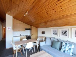 a living room with a blue couch and a table at Apartment Le Hameau-7 by Interhome in Les Collons
