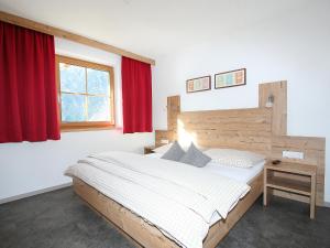 sypialnia z łóżkiem i czerwonym oknem w obiekcie Apartment s' HimmelReich-1 by Interhome w mieście Huben