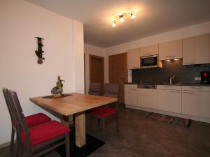 kuchnia z drewnianym stołem i czerwonymi krzesłami w obiekcie Apartment s' HimmelReich-1 by Interhome w mieście Huben +20 zdjęć