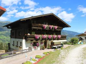 un edificio con flores a un lado. en Holiday Home Umbichl by Interhome en Uttendorf