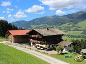 a house on a hill with mountains in the background at Holiday Home Umbichl by Interhome in Uttendorf