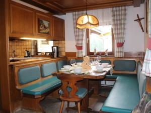 eine Küche mit einem Holztisch mit Stühlen und einer Tableasteryasteryasteryastery in der Unterkunft Holiday Home Umbichl by Interhome in Uttendorf