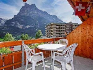 a white table and chairs on a balcony with a mountain at Apartment Chalet Abendrot apARTments-10 by Interhome in Grindelwald