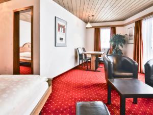 グリンデルワルトにあるApartment Chalet Abendrot-18 by Interhomeのベッド、テーブル、椅子が備わるホテルルームです。