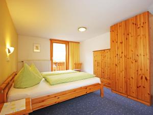 Schlafzimmer mit einem Bett und einem Holzschrank in der Unterkunft Holiday Home Josefine by Interhome in Jetzmund