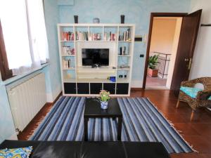 a living room with a tv and a table at Apartment Blue Lagoon by Interhome in  Monvalle 