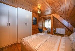 a bedroom with a bed and a wooden ceiling at Dva Javora -SPA Apartment in Kolašin